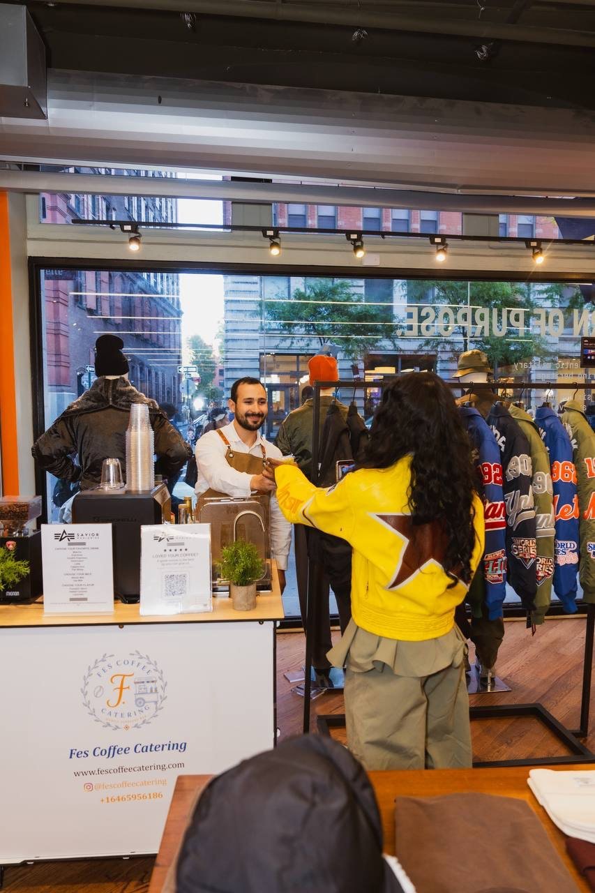 Fes Coffee cart set up inside a clothing store with a guest in a yellow jacket at the counter