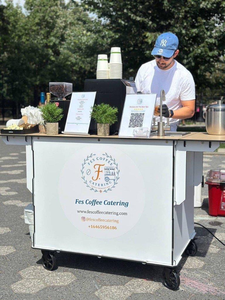 Barista preparing drinks at outdoor Fes Coffee cart