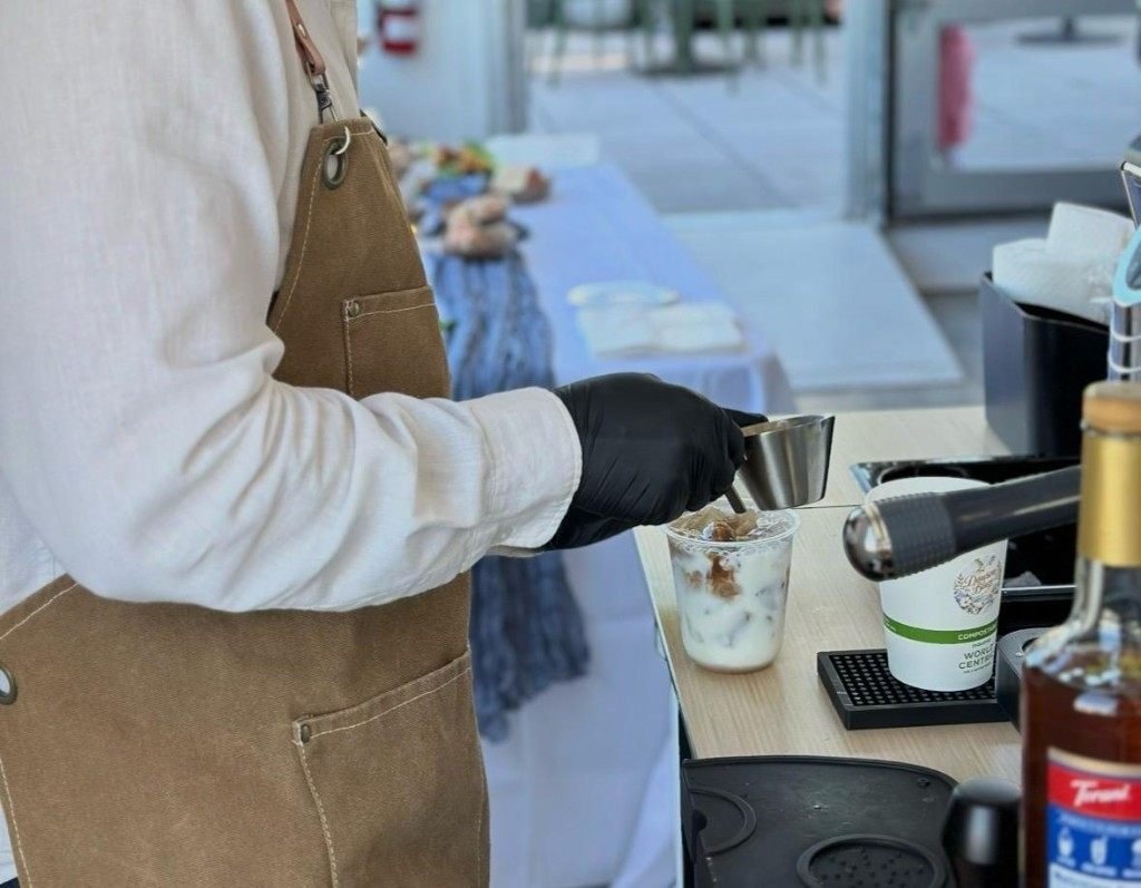 Barista finishing an iced latte at the Fes Coffee cart