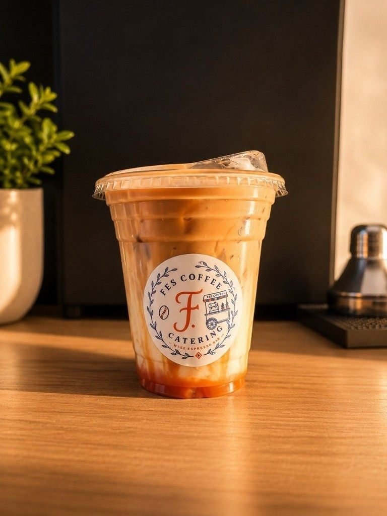 Iced caramel latte in a Fes Coffee branded cup