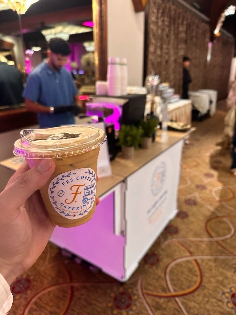 Iced latte with Fes Coffee cart glowing pink at an event